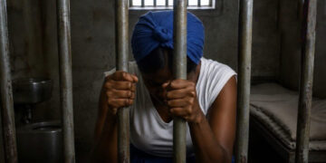 A symbolic silhouette of a woman behind bars, representing Lydia Aboagye's life sentence for killing her husband in Omanjor.
